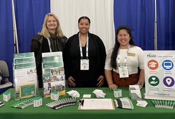 Image of three CPH employees standing behind the CPH APHA table while smiling 